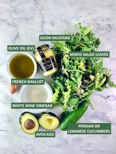 the ingredients for an avocado salad laid out on a marble surface