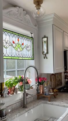 a kitchen sink under a stained glass window