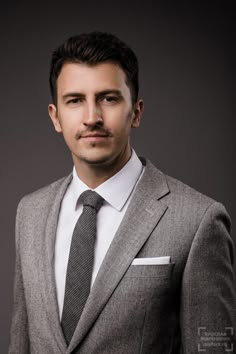 a man in a suit and tie posing for a photo