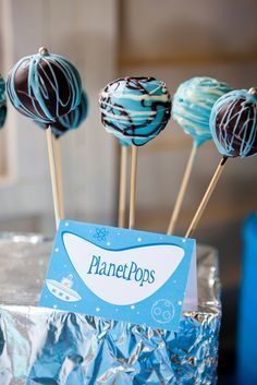 there are some chocolate lollipops with blue icing on the top and white frosting on the bottom