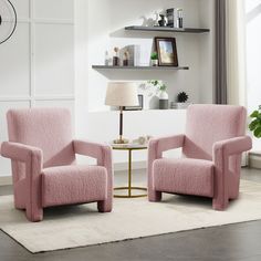 two pink chairs sitting next to each other on a rug