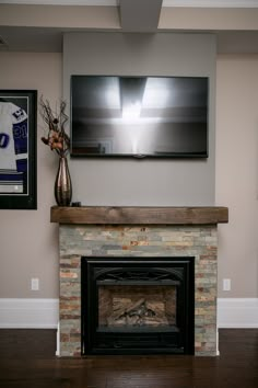 a flat screen tv mounted on the wall above a fireplace