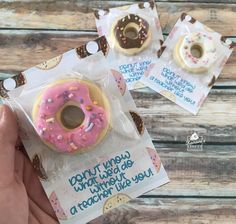 two donuts with pink frosting and sprinkles are in a package