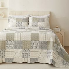 a bed with a white headboard and two pillows sitting on top of it next to a book shelf