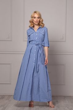 A button-down, checkered blue and white maxi dress with roll-up sleeves is a captivating and versatile addition to your wardrobe. This dress combines classic elegance with a hint of casual charm. The small checkered pattern in serene blue and white hues adds a touch of sophistication, while the maxi length exudes timeless grace. The roll-up sleeves offer versatility, allowing you to adjust your look effortlessly. You can wear them down for a polished appearance or roll them up for a relaxed, car Plaid Midi Dress With Buttons, Spring Plaid Maxi Dress, Elegant Plaid Cotton Dress, Gingham Dresses With Button Closure For Work, Gingham Dresses With Buttons For Spring, Gingham Dress With Button Closure For Work, Spring Gingham Dresses With Buttons, Plaid Button-up Dress For Daywear, Spring Button-up Gingham Dresses