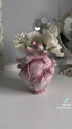 a vase filled with flowers sitting on top of a white table next to a mirror