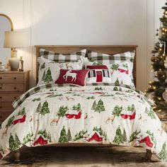 a bed with christmas themed sheets and pillows