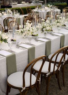 the tables are set with white flowers and candles