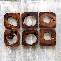 four pieces of wood sitting on top of a cement floor with holes in the middle