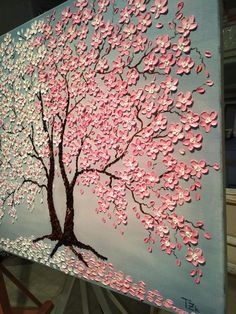 a painting with pink and white flowers painted on the side of a blue canvas,