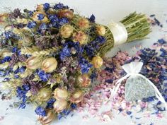 a bouquet of dried flowers next to a bag of confetti