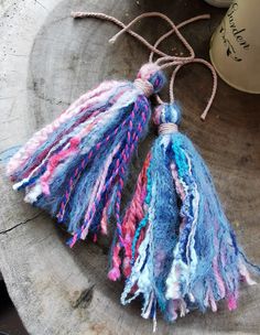 two tassels are sitting on top of a piece of wood