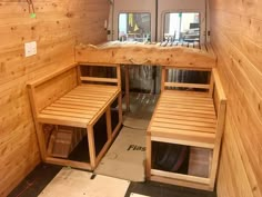 the inside of a small wooden cabin with bunk beds and mirrors on the wall above