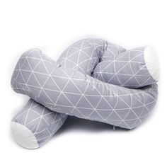 a gray and white stuffed animal sitting on top of a floor next to a pillow