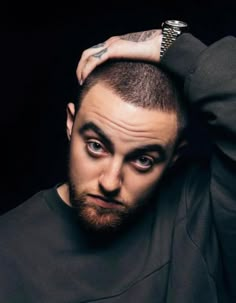 a man with a beard and piercing on his head is looking at the camera while wearing a black sweatshirt