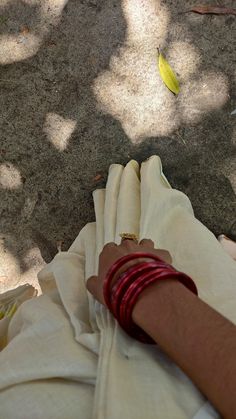 a person's arm with bracelets on it and a banana in the background