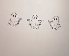 three ghost stickers in the shape of fingers pointing at each other with eyes drawn on them