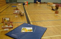 there are many books on the floor in this gym with balls and chairs around them