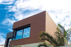 a modern house with palm trees and blue sky in the background