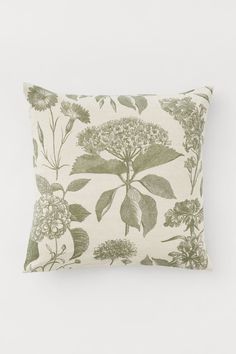 a green and white pillow with flowers on it