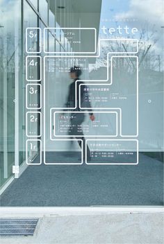 a man walking past a glass building with white lines on it