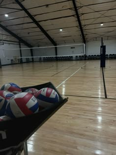 an empty gym with volleyballs in it