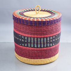 a woven basket with a handle on the top is sitting in front of a gray background