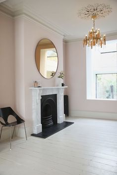 a living room with a fire place and a mirror on the wall next to it