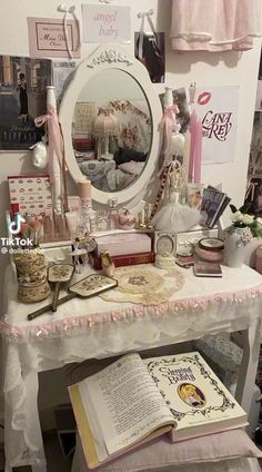 a white table topped with a mirror and lots of books