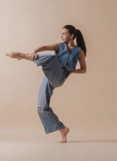 a woman is doing a dance move with one leg in the air and her other hand behind her head