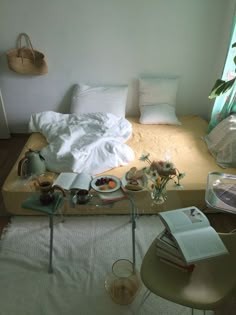 an unmade bed with white linens and pillows in a bedroom next to a window