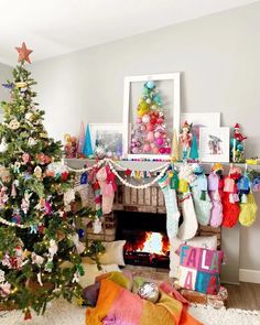 a decorated christmas tree sitting in front of a fire place