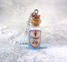 "Eternal Life Bottle Necklace - Magic Potion Mini Glass Bottle Charm - Blue Liquid Shimmer Live Forever Infinity Fountain of Life Spells This unique totally fun \"Eternal Life\" Glass Bottle Necklace contains a super shimmery {top secret} formula to turn back the hands of time so you can stay young forever! Ok, not really but it's fun to pretend! Give the bottle a gentle shake and you will see just how shimmery and swirly this liquid is! Please photos to get an idea of what this concoction looks Potion Vial, Cinderella Fairy Godmother, Cork Necklace, Bibbidi Bobbidi Boo, Necklace Fairy, Magic Bottles, Mini Glass Bottles, Silver Link Chain, Bottle Jewelry