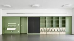 an empty room with green walls and shelves