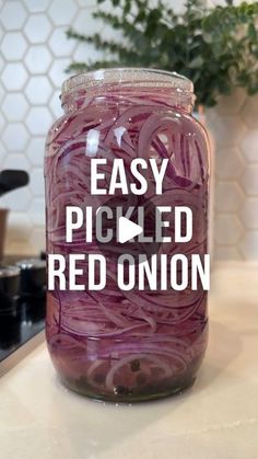 a jar filled with red onions sitting on top of a counter