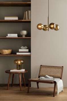 a chair and table in a room with bookshelves on the wall behind them