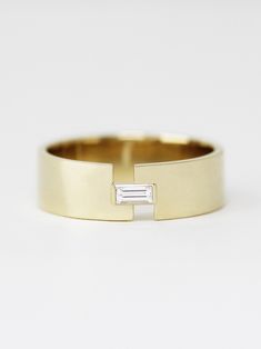 a yellow gold ring with a baguette cut in the middle