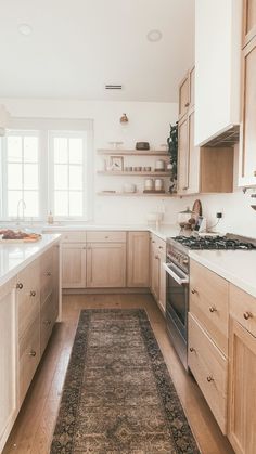 a kitchen with wooden cabinets and an area rug in front of the stove top oven