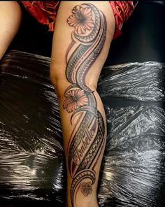 a woman's leg with a tattoo on it and flowers in the middle of her legs