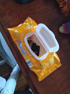 a yellow plastic bag sitting on top of a wooden table