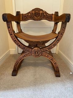 a wooden chair sitting on top of a carpeted floor next to a wall and door