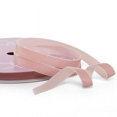 a roll of pink satin ribbon on a white background