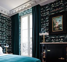 a bedroom with green wallpaper and blue bedding