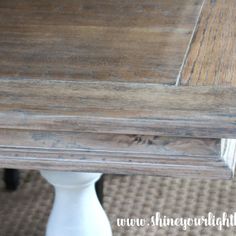 a close up of a wooden table with white legs and wood grain on the top