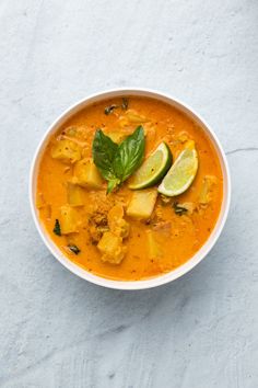 a white bowl filled with soup and garnished with lime