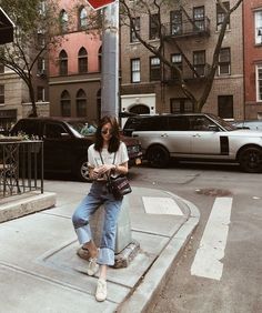 a woman sitting on a stop sign in the city