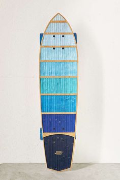 a surfboard made out of wood with blue stripes on the bottom and sides, against a white wall