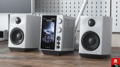 two speakers sitting on top of a wooden table