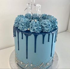 a blue birthday cake with flowers on top