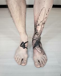 a man's bare feet with black ink on the lower part of his leg